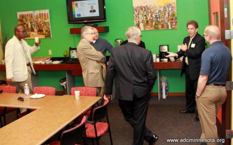 Tom Horner and gathered participants chat informally